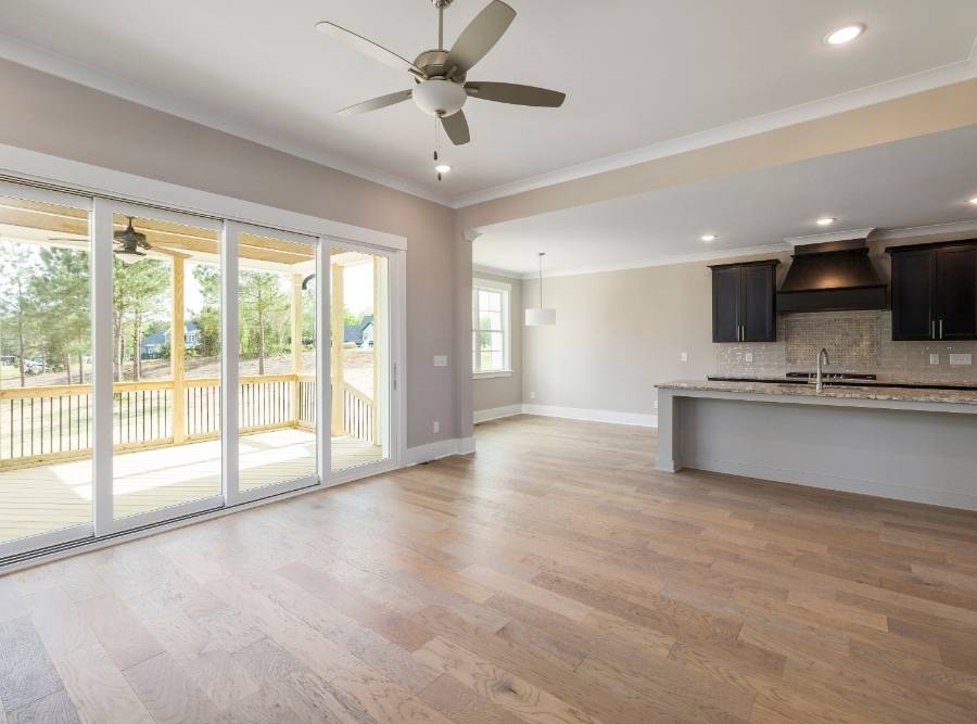 Open-concept kitchen and living area with luxury vinyl plank (LVP) flooring and large sliding glass doors