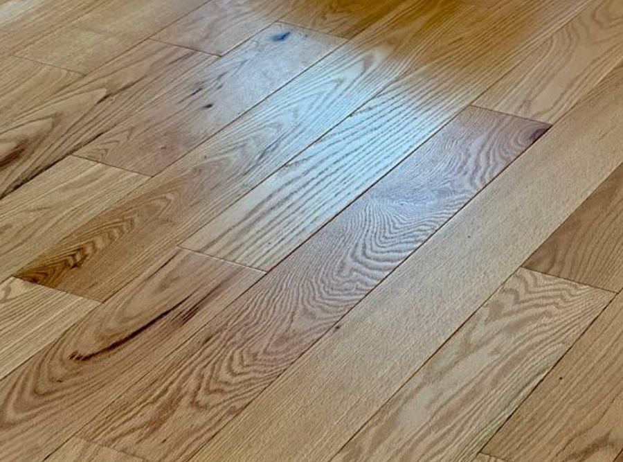 Close-up view of natural engineered wood flooring with visible grain patterns and warm tones