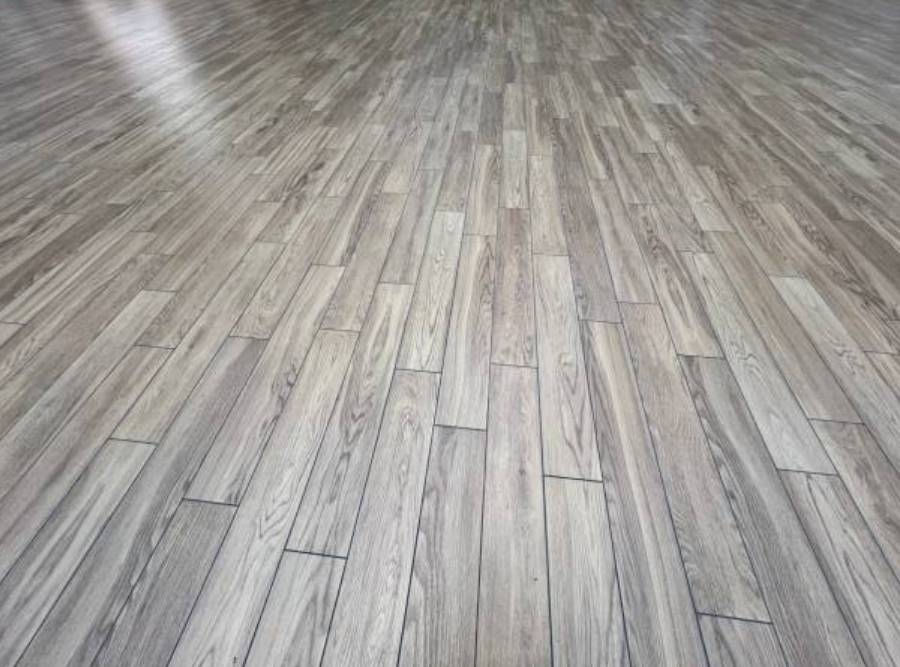 Close-up view of luxury vinyl plank (LVP) flooring with a gray wood-look finish.