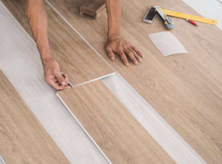 Worker installing luxury vinyl plank (LVP) flooring with wood-look finish