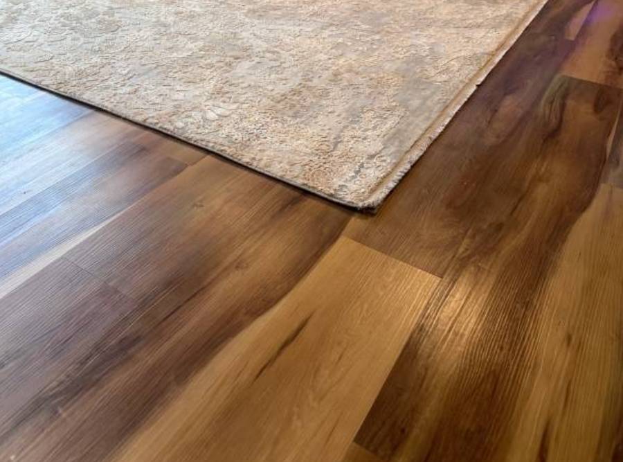 Luxury vinyl plank (LVP) flooring with a natural wood finish and area rug in a living space